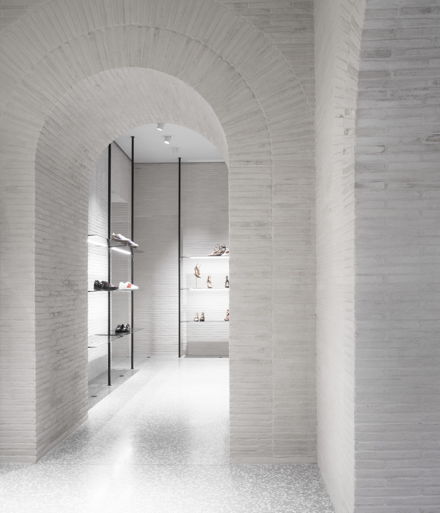 Valentino Flagship Store in Rome develops between Piazza di Spagna and Piazza Mignanelli. The first floor contains light, non-structural arches in polished white plaster to enhance the products.
