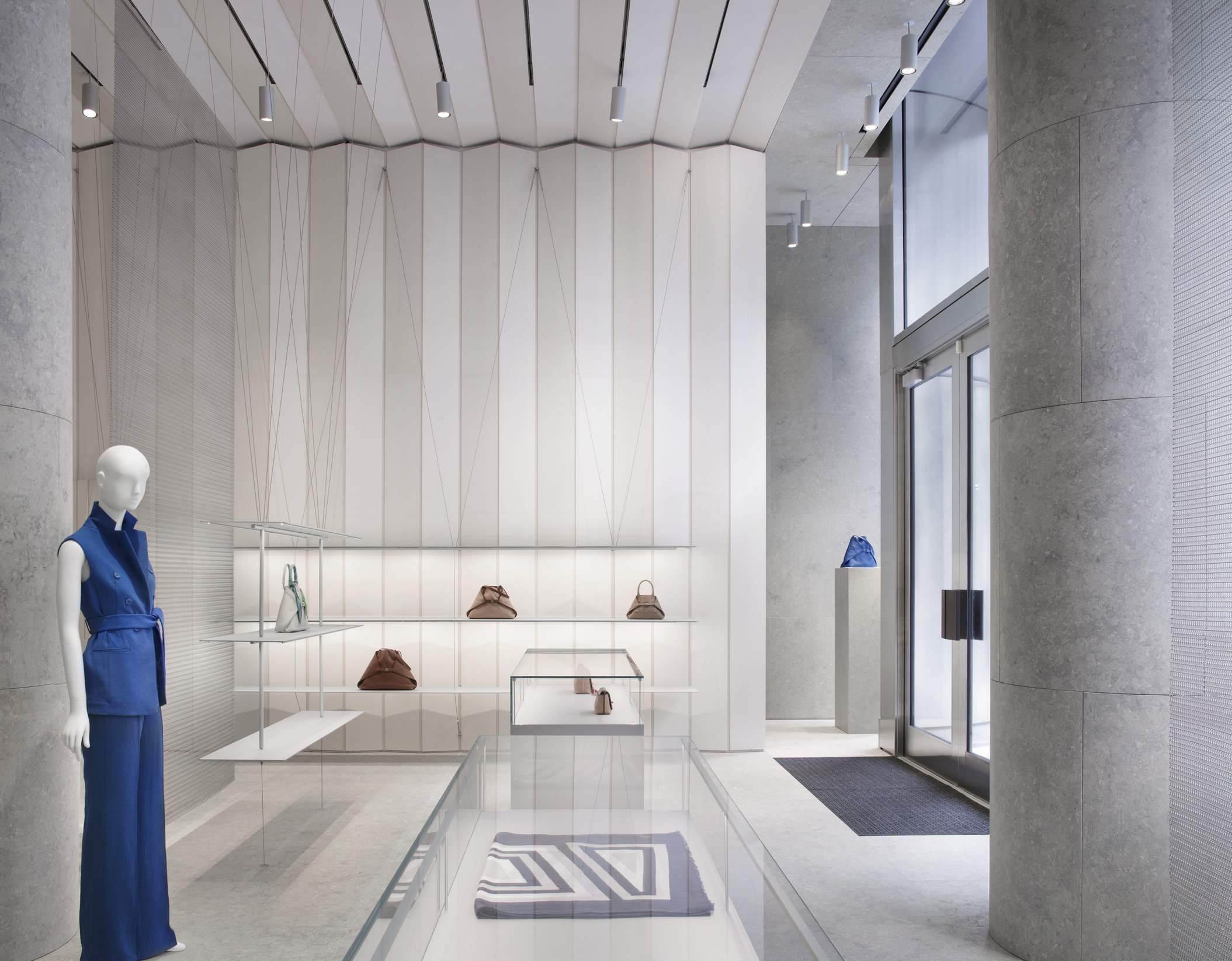 Akris boutique concept develops through a three-dimensional architecture and a light-weight display system.